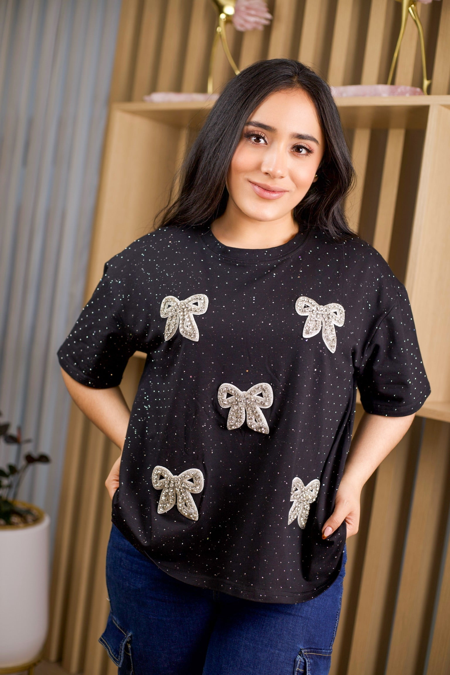Camiseta oversize unicolor con brillos y aplique de moño.