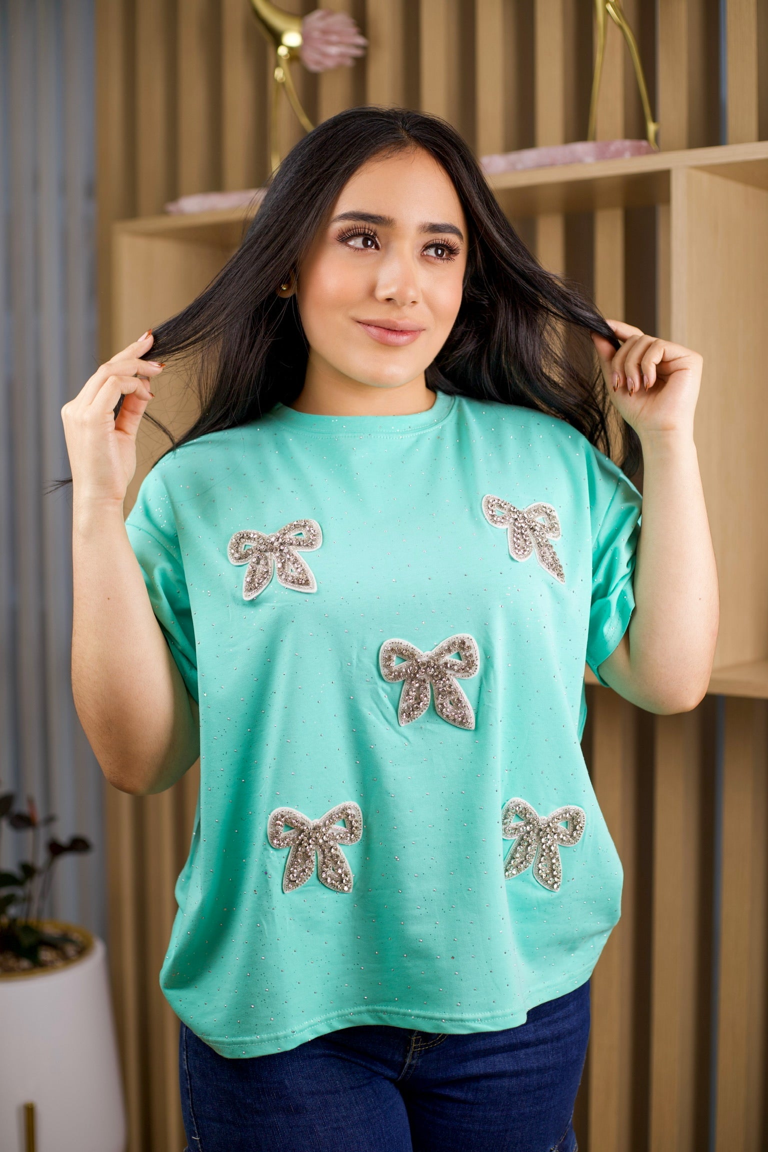 Camiseta oversize unicolor con brillos y aplique de moño.