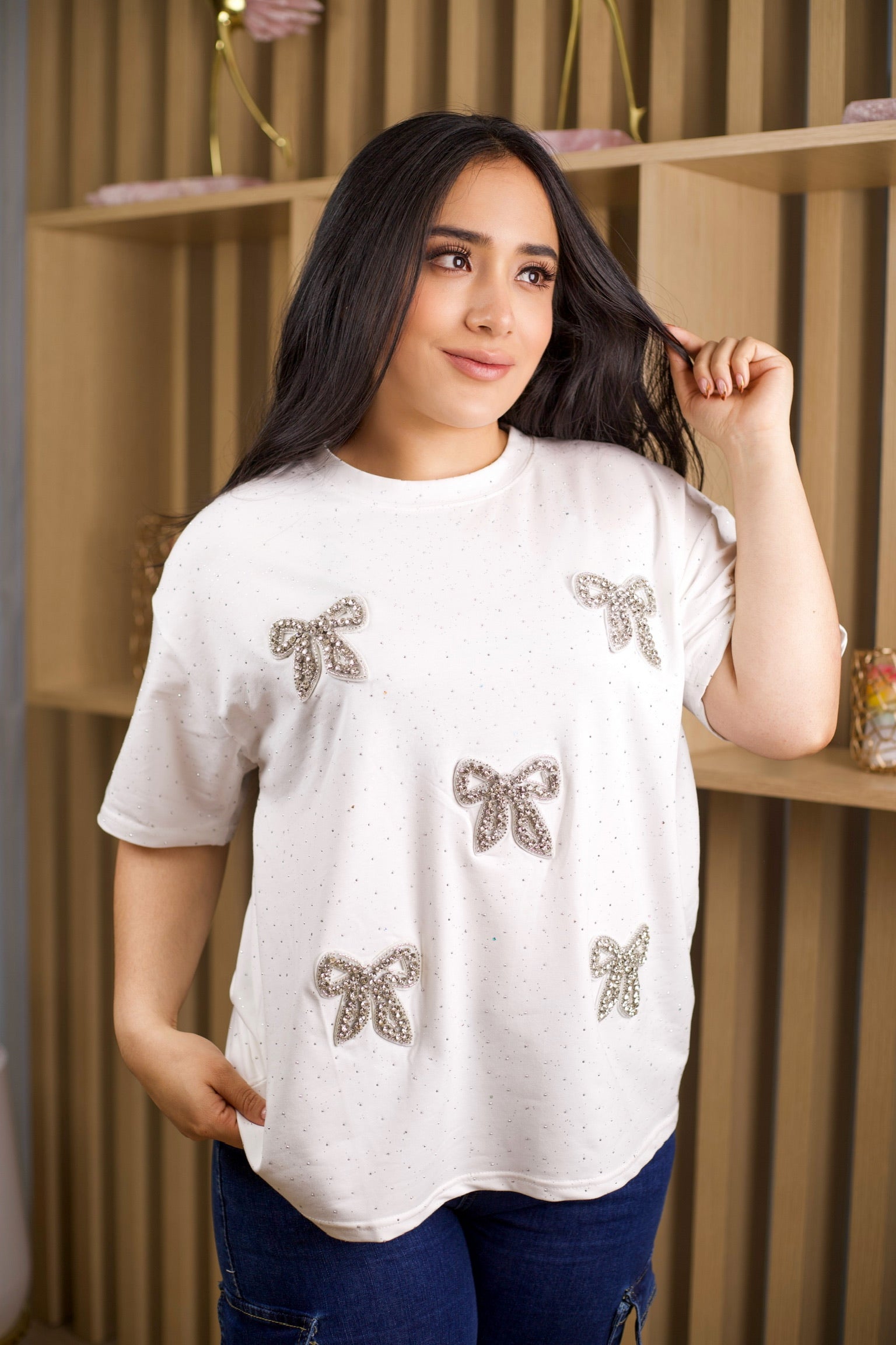 Camiseta oversize unicolor con brillos y aplique de moño.